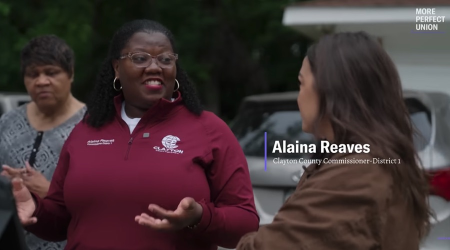 A county commissioner speaking with a member of Congress outside a home